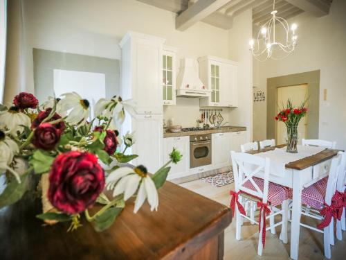a kitchen and dining room with a table with flowers on it at La finestra sul Teatro in Cortona