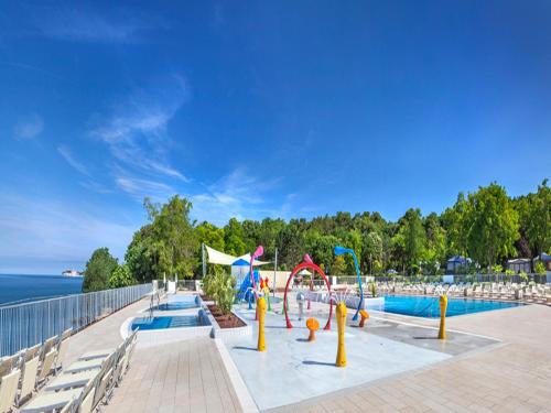 a swimming pool with a playground with a slide at Easyatent Mobile home Lanterna in Poreč
