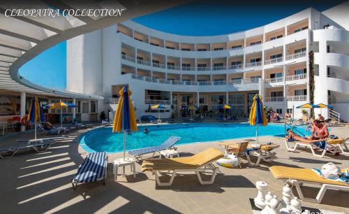 a resort with a pool and chairs and a building at Kris Mari in Kardamaina