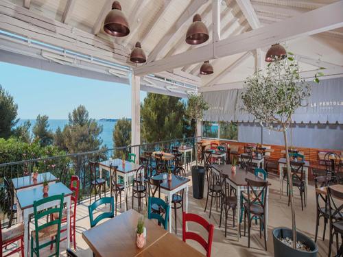 a restaurant with tables and chairs and a balcony at Easyatent Mobile home Lanterna in Poreč