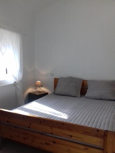 - une chambre avec un lit avec un cadre en bois et une fenêtre dans l'établissement Gite Laulan, à Francs