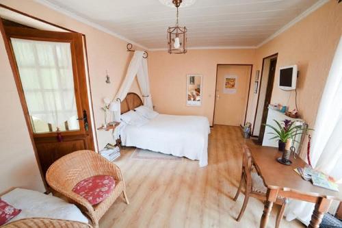 1 dormitorio con 1 cama, 1 mesa y 1 silla en Chez Camille, en Étrigny