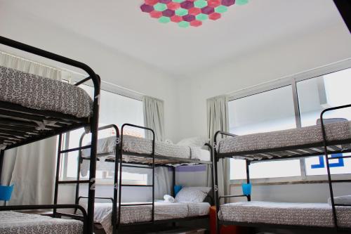 a group of bunk beds in a room with a window at Rich & Poor Hostel Albufeira in Albufeira