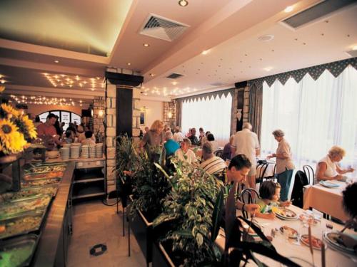 un grupo de personas sentadas en mesas en un restaurante en Easyatent FKK Safari tent Koversada Naturist - clothes free, en Vrsar