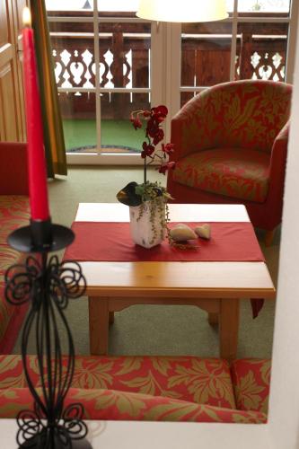 a room with a table with a plant on it at Landhaus Alpensonne in Schattwald
