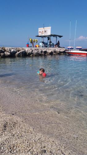 a child swimming in the water at the beach at Art Studios Benitses in Benitses