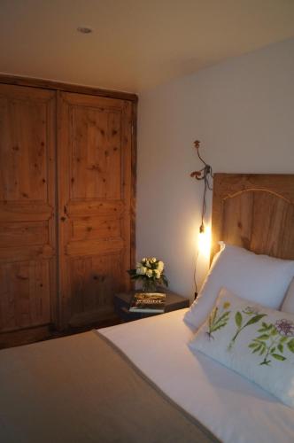 a bedroom with a bed with a wooden headboard and a lamp at Logis Hôtel O Lodge in Cleppé