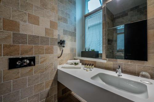 a bathroom with a sink and a mirror at Artagonist Art Hotel in Vilnius