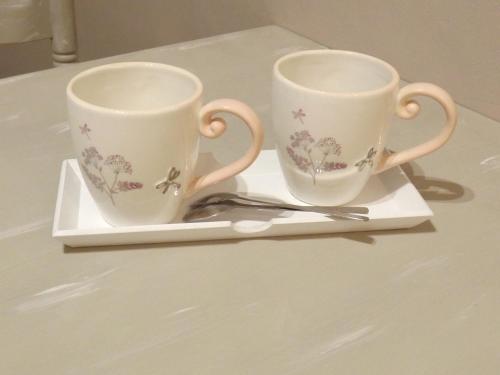 two cups on a plate with a pair of scissors at Le Compostelle de Conques in Conques-en-Rouergue