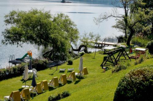 a park with chairs and tables and a playground next to the water at Waldstrand Berger in Seeboden