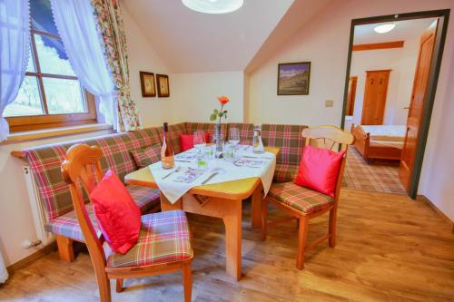 a dining room with a table and a couch at Appartementhaus Sonne in Ramsau am Dachstein