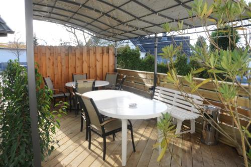a patio with tables and chairs and a fence at Pension Bella Vista in Bochum
