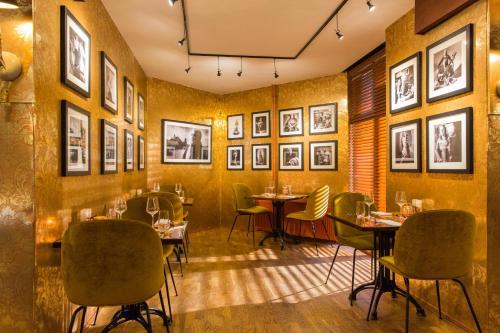 a restaurant with tables and chairs and pictures on the walls at Restaurant Hotel Merlet in Schoorl