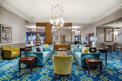 a living room with blue couches and chairs at Leonardo Hotel - Formerly Jurys Inn and Conference Venue Aberdeen Airport in Dyce