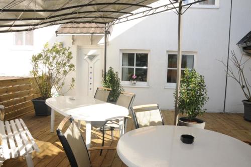 two tables and chairs in a patio with plants at Pension Bella Vista in Bochum