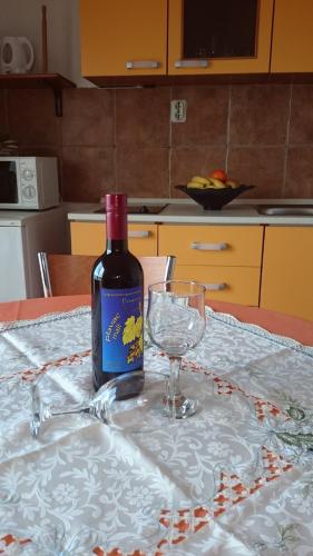 a bottle of wine sitting on a table with a glass at Apartment Pečarević - a holiday with a stunning view in Vis