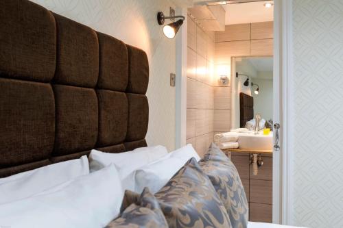 a bedroom with a bed and a bathroom with a sink at Hotel Shepherds Bush London in London