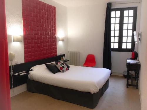 - une chambre avec un lit et un mur rouge dans l'établissement Hôtel De La Loge, à Perpignan