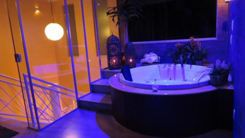 a bathroom with a tub with purple lighting at Pousada Casa das Flores in Sao Jorge