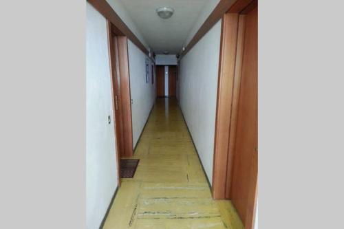 an empty hallway with a long floor and white walls at Rifugio Di Pace in Folgaria