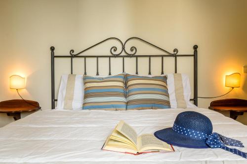 タオルミーナにあるSara's Houseの帽子と本を載せたベッド