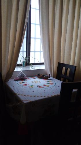 a bedroom with a bed and a window with curtains at Casa Serena in Guayaquil