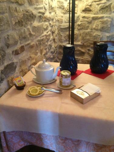 a table with a tea pot and vases on it at Agriturismo Il Casalone in Badia Tedalda