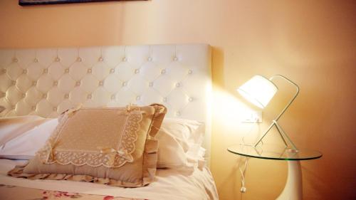 a bed with a pillow and a table with a lamp at Ridolfi Guest House in Florence