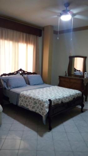 a bedroom with a bed with a dresser and a mirror at Casa Serena in Guayaquil