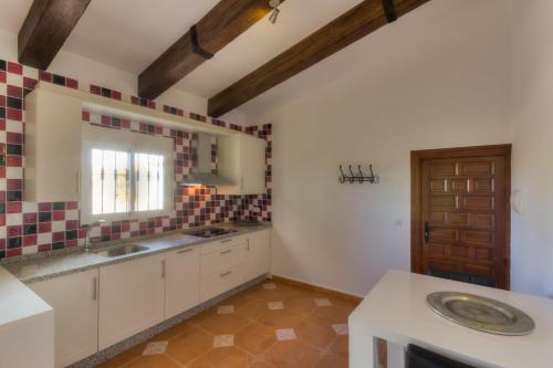 a kitchen with white cabinets and a sink and a window at Villa Damara in Albox