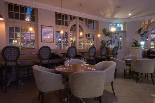 a restaurant with tables and chairs in a room at The Kings Head Hotel in London