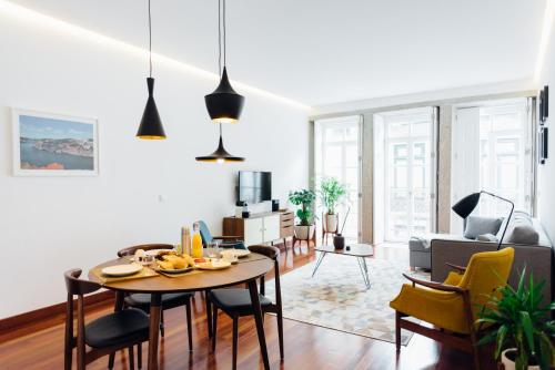 uma sala de estar com mesa e cadeiras em Myo Design House no Porto