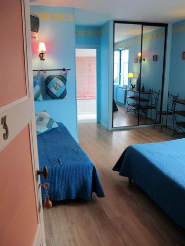 - une chambre bleue avec un lit et un miroir dans l'établissement Hôtel Au Bord du Monde, à Neuvy-sur-Barangeon