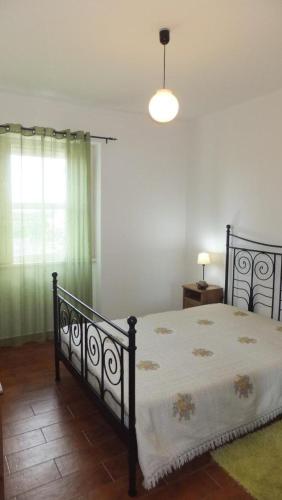 a bedroom with a bed and a window with a light at Casa do Pico Madalena in Madalena
