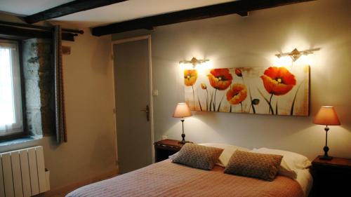 a bedroom with a bed with two lamps and a painting on the wall at Chambres d'Hotes Belard in Plonévez-Porzay