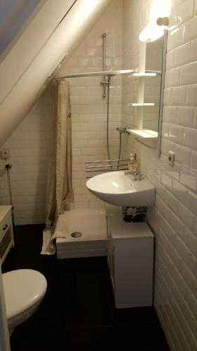 a white bathroom with a sink and a toilet at Vakantiehuis Limburg - Landgraaf in Landgraaf