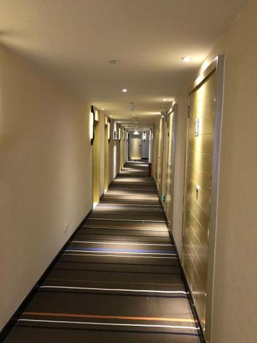 a hallway of a hotel with a long aisle at Hotel Pomelo Premier 西柚臻选武昌站酒店 in Wuhan