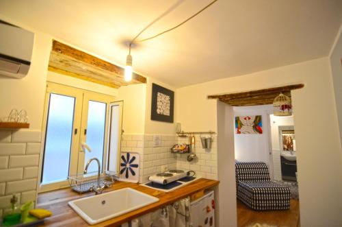 een keuken met een wastafel en een raam in een kamer bij La Chiromante in Napels