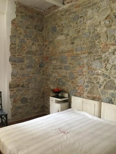 a bedroom with a stone wall and a bed at Appartamento Al Tiglio in Lucca