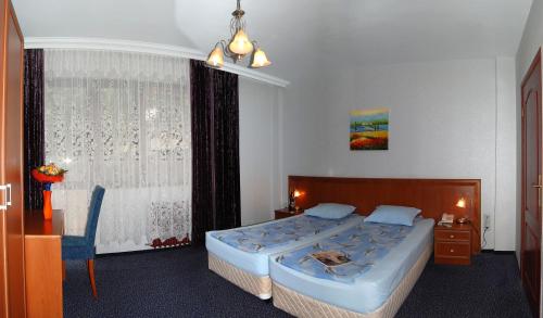 a bedroom with a large bed and a window at Hotel Kibella in Sofia