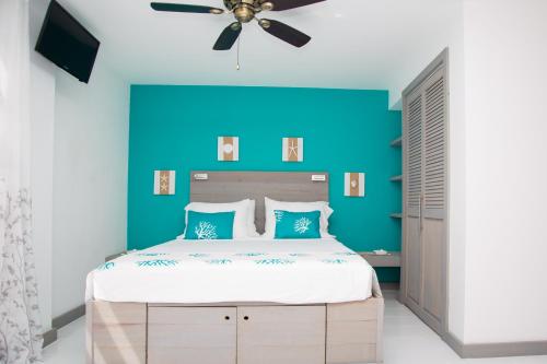 a bedroom with a large bed with a blue accent wall at Bellevue Suites in Buckleys