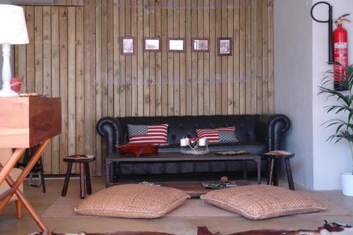 a living room with a black couch with patriotic pillows at Les Suites in Santa María de Palautordera