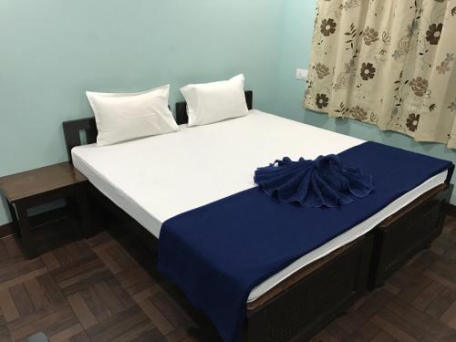 een bed in een kamer met een blauw en wit matras bij Leisure Cottages in Baga