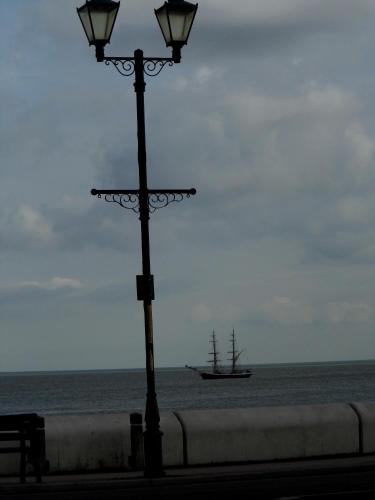 a street light with a boat in the ocean at Waterfront Hotel in Deal