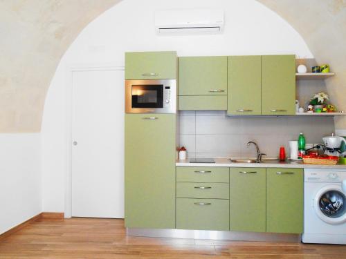 a kitchen with green cabinets and a washing machine at Il Trifoglio in Matera