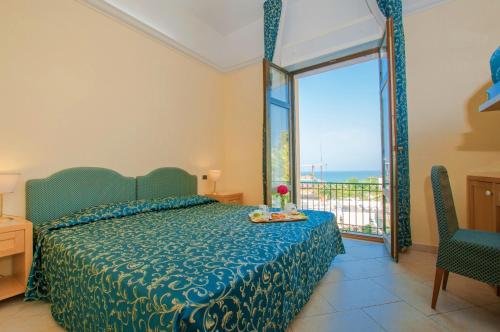 Schlafzimmer mit einem Bett und Meerblick in der Unterkunft Park Hotel Villa Americana in Rodi Garganico