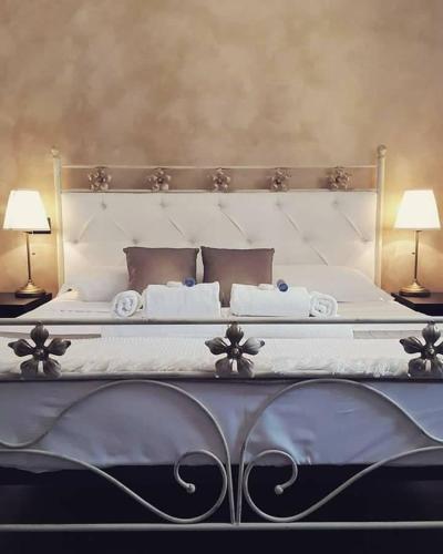 a bedroom with a large white bed with two lamps at B&B Villa Jonica in Gallipoli