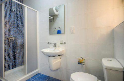 a white bathroom with a toilet and a sink at Water's Edge Apartment in St. Paul's Bay