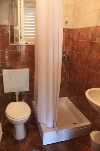 a bathroom with a toilet and a shower curtain at Apartman Anka in Viganj