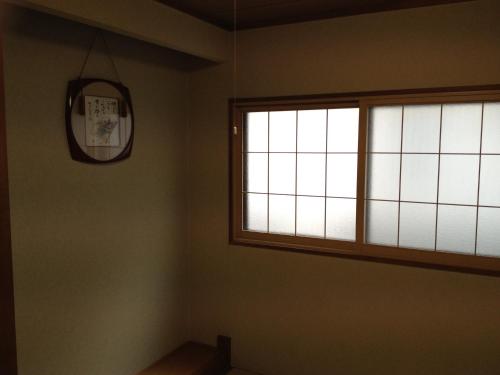 a window in a room with a clock on the wall at Iroha Ryokan in Aomori
